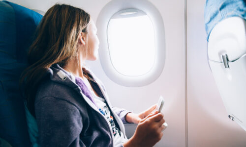 Woman looks out airplane window