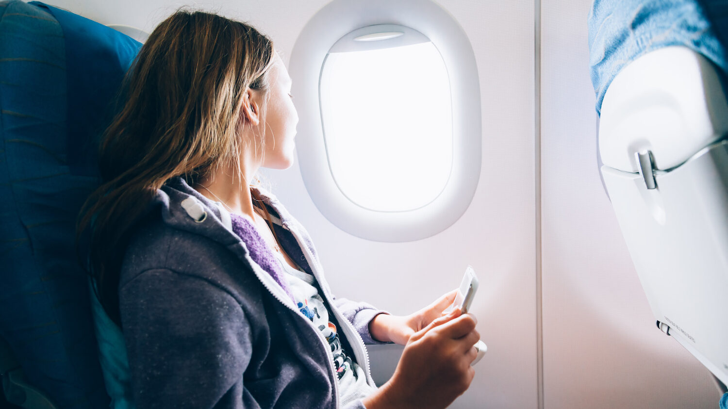 Woman looks out airplane window