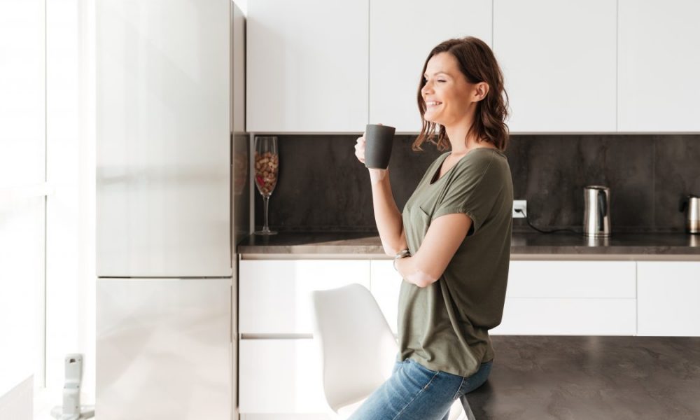 Woman drinks coffee and smiles