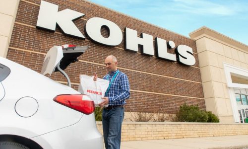 Kohl's worker puts bag in shopper's trunk outside store