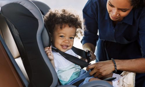 Child in car seat, mom buckling in