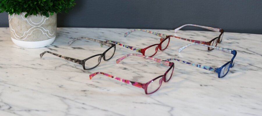 5 pairs of reading glasses on table