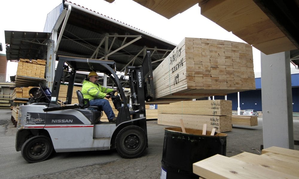 Man in forklift moves 2x4s at lumber yard