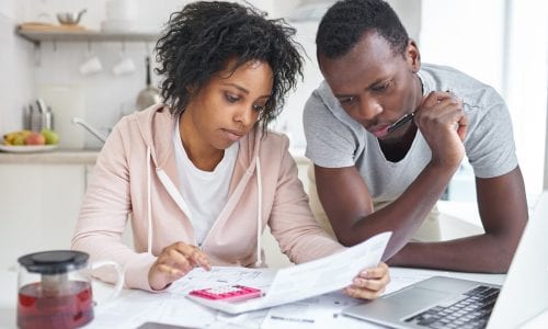 Couple goes over finances at kitchen table