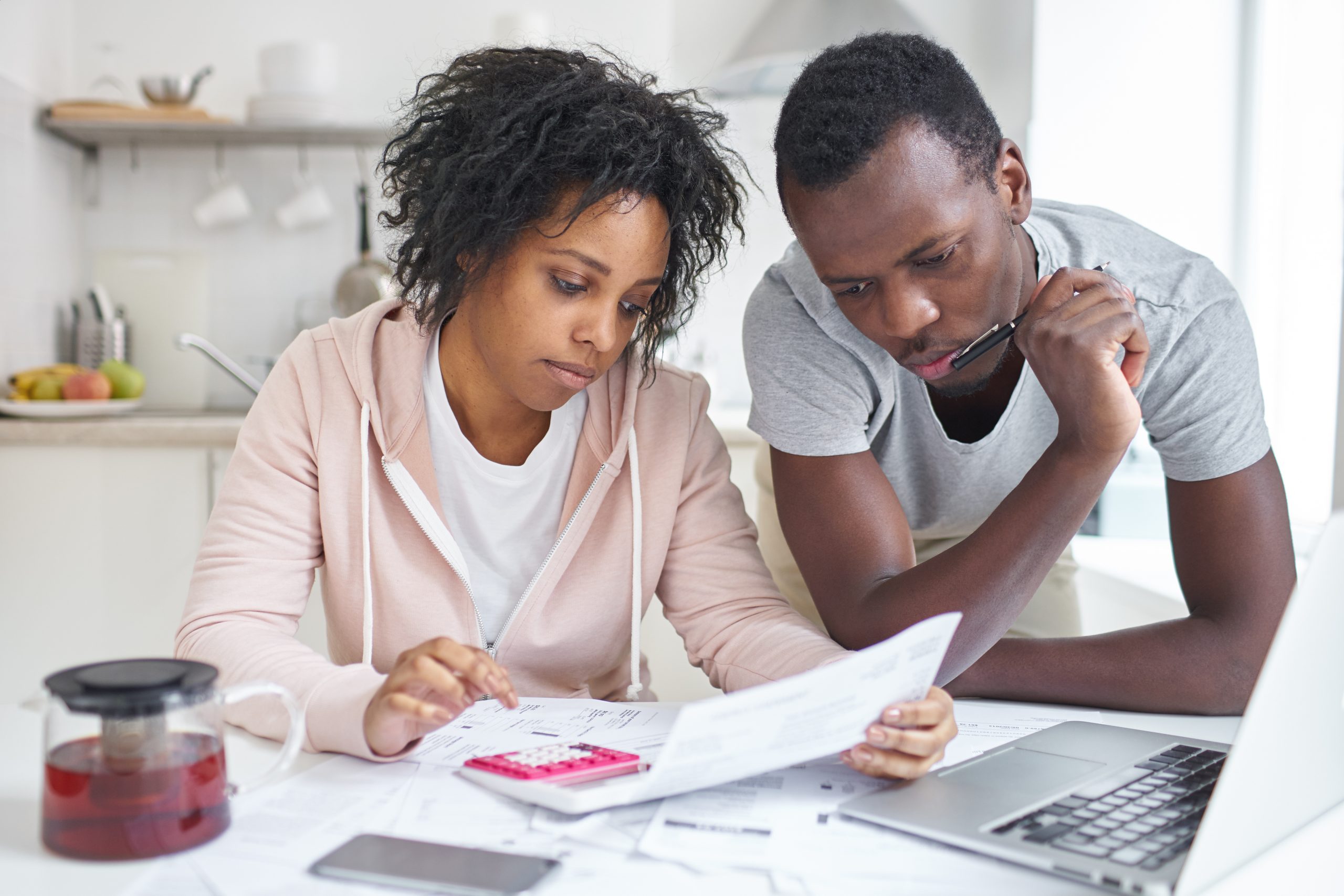 Couple goes over finances at kitchen table