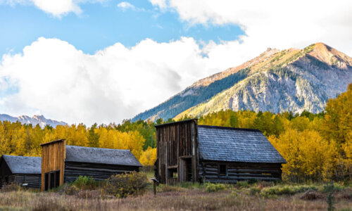 abandoned cabins next to mountain backdrop