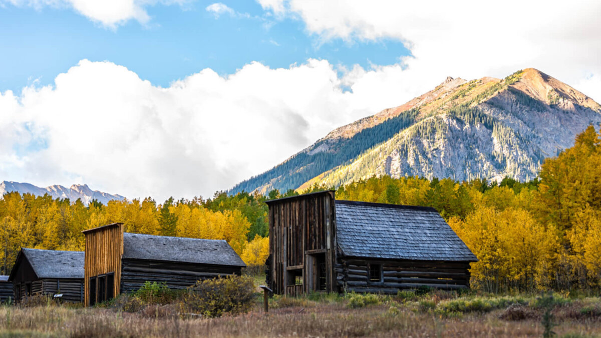 abandoned cabins next to mountain backdrop