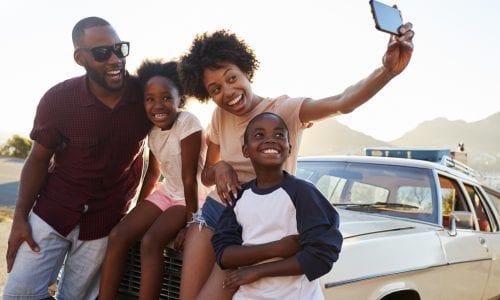 Happy family on road trip vacation posing for selfie
