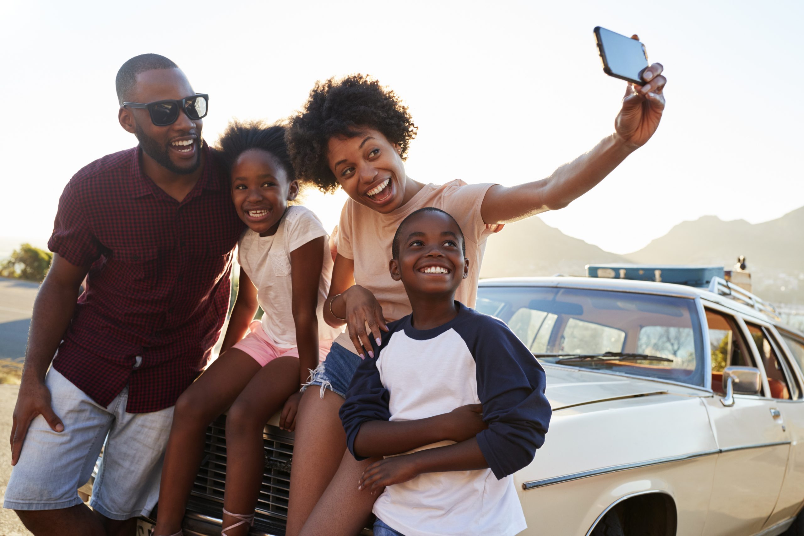 Happy family on road trip vacation posing for selfie