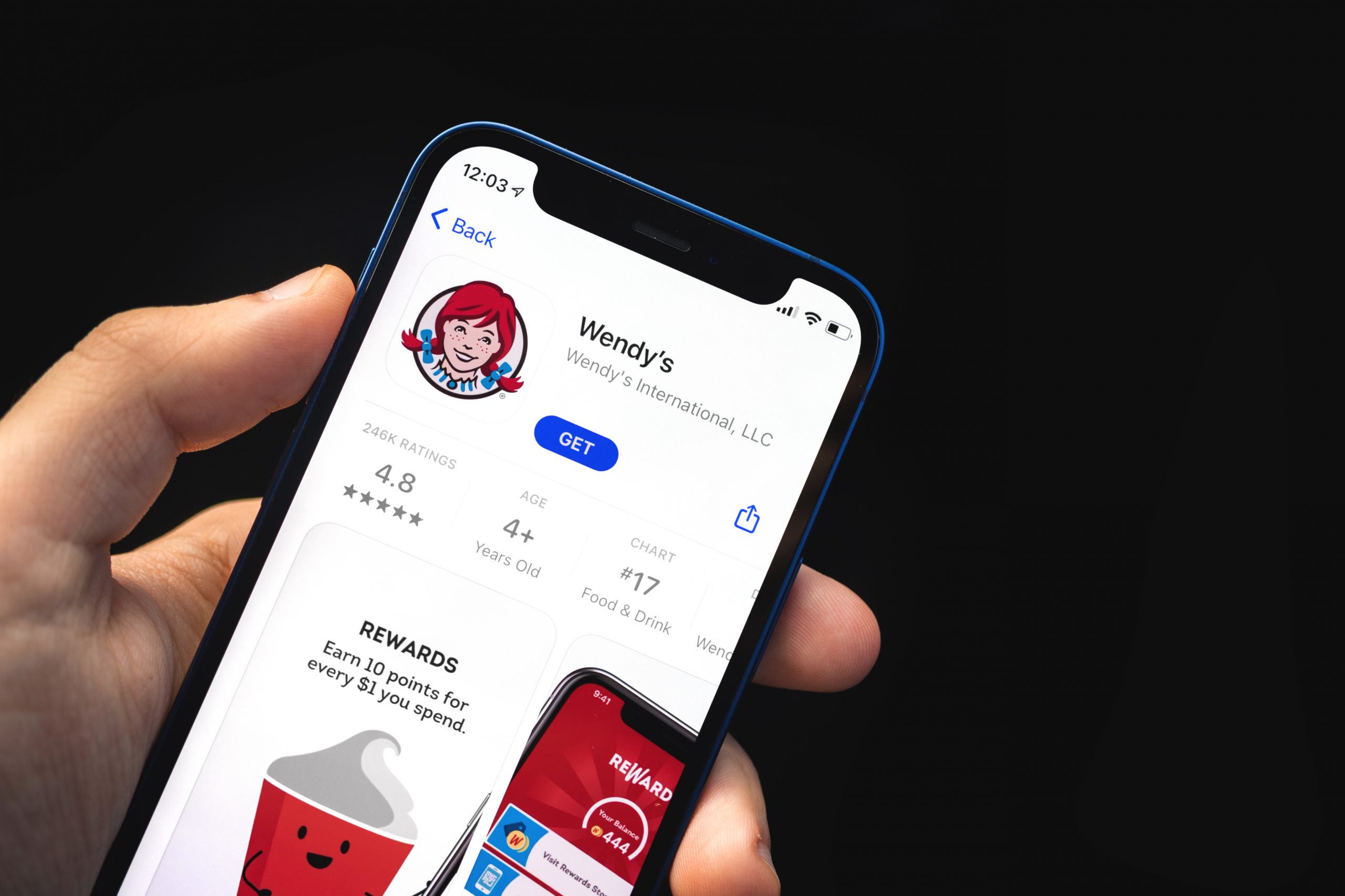Hand holds phone showing Wendy's app