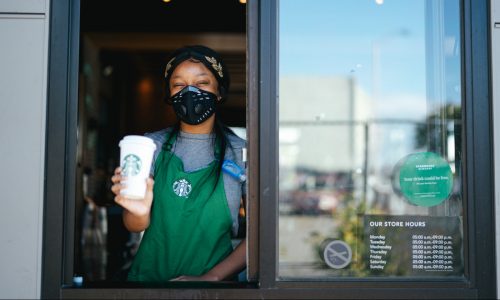 Starbucks barista holds coffee at drive-thru window