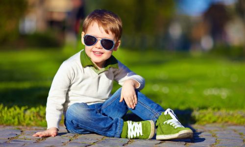 Cute little boy wearing sunglasses, green shoes