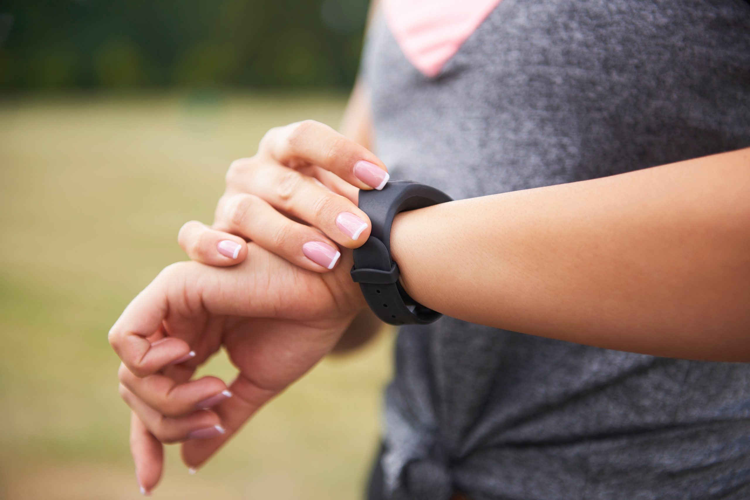 Woman checks Fitbit fitness watch