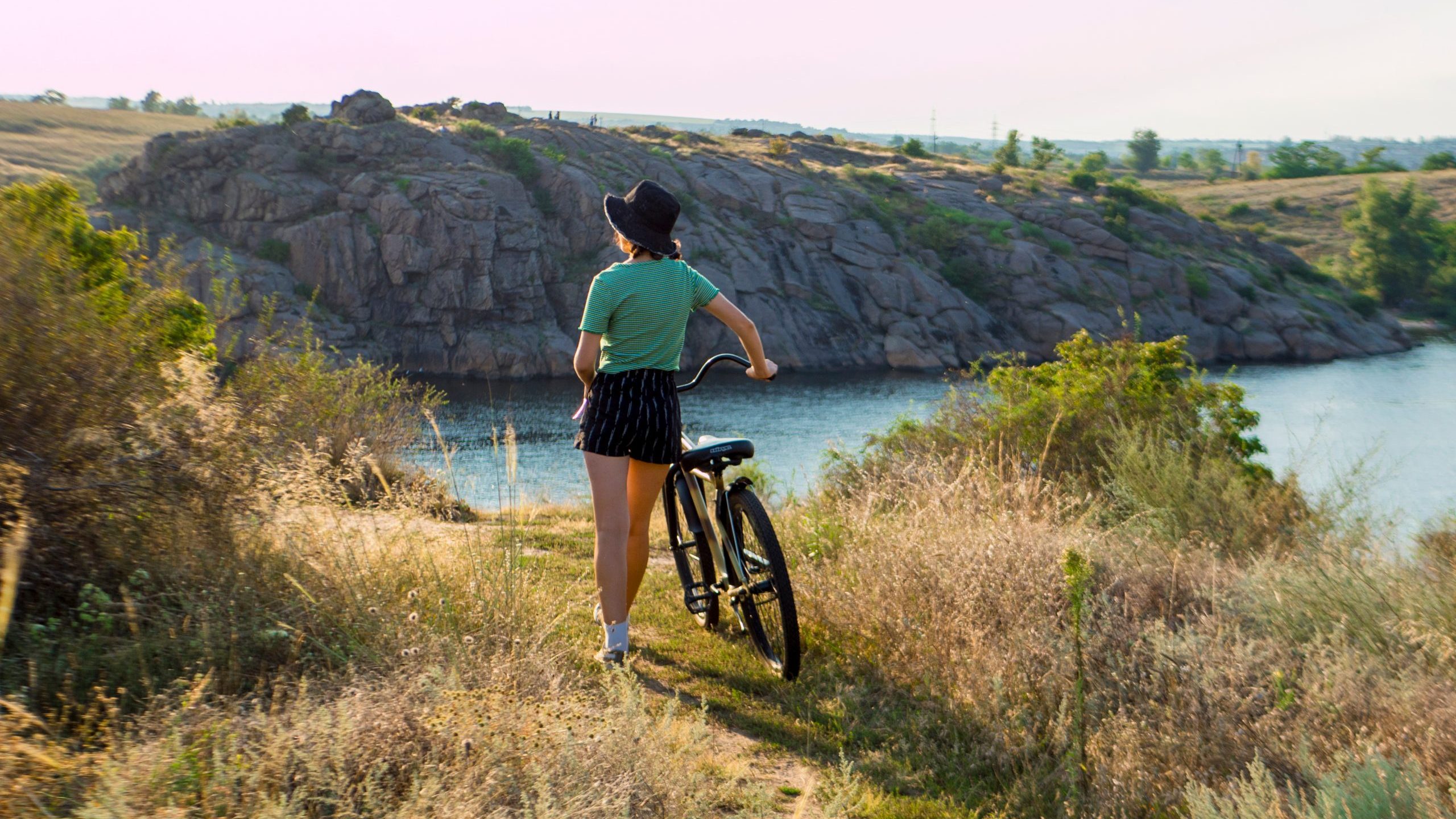Woman looks at ocean with cruiser bike