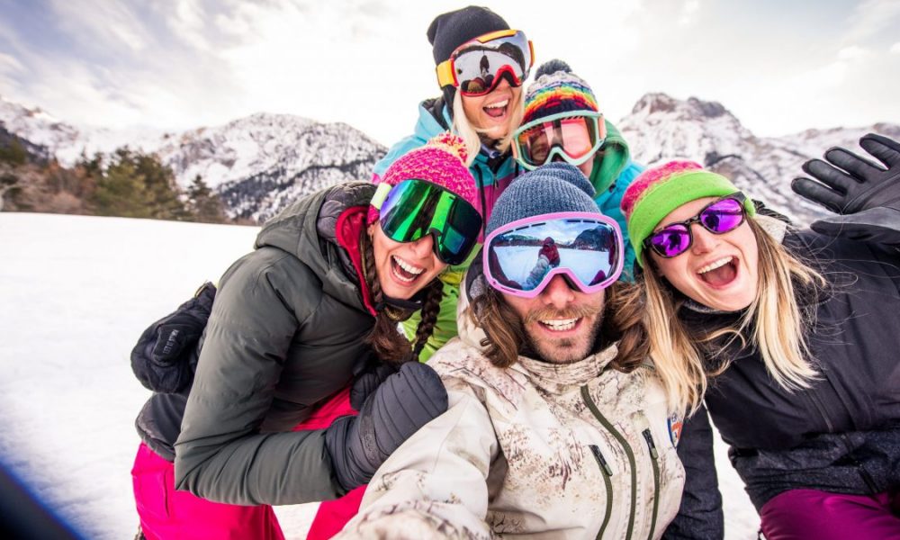 Group of snowboarders smiling on a snowy slope.