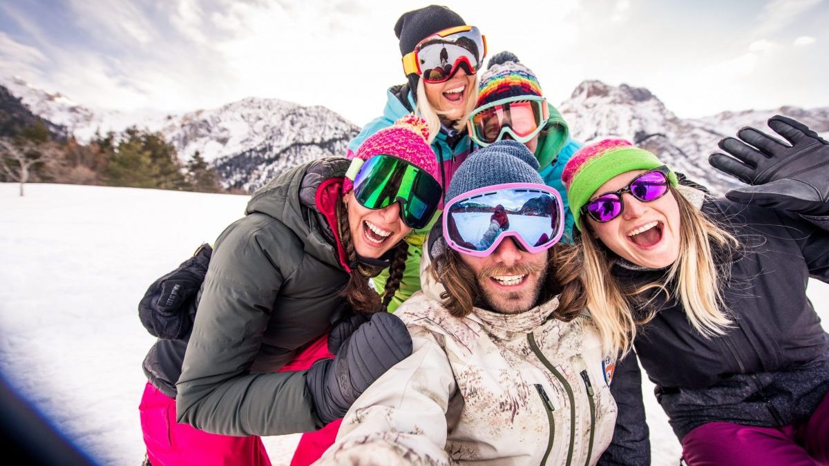 Group of snowboarders smiling on a snowy slope.