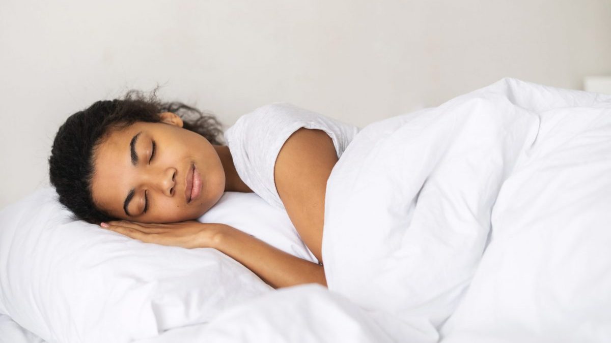 Woman sleeps on her side in bed