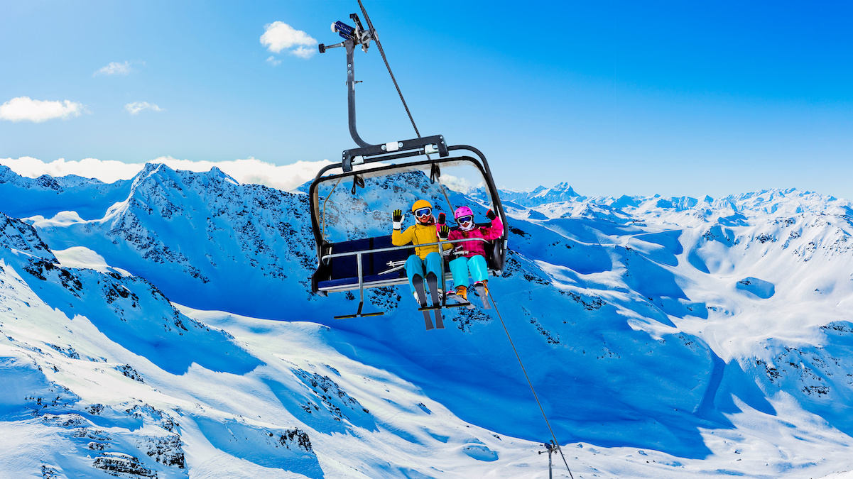 Skiers using a ski lift to get up a mountain.