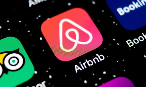 Airbnb logo is shown on smartphone