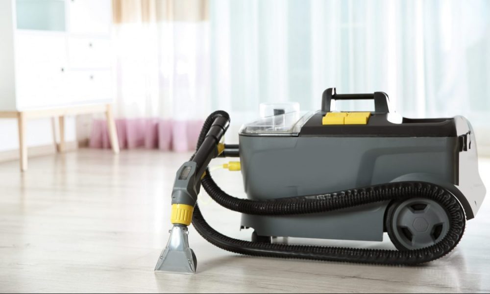 A wet dry vacuum cleaner sits on a floor.