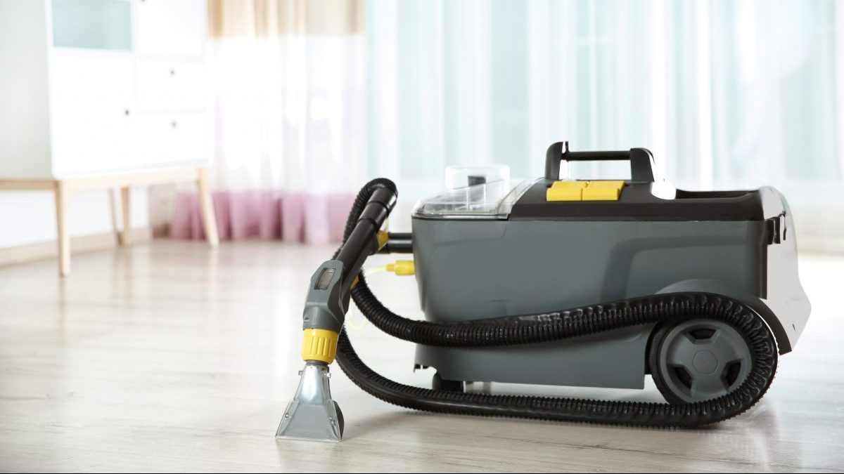 A wet dry vacuum cleaner sits on a floor.