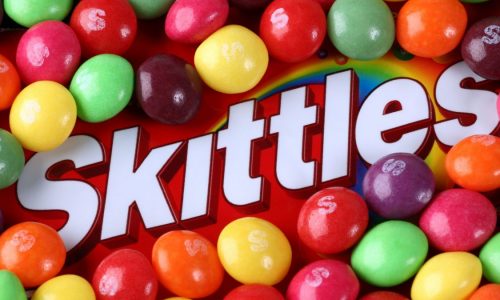 The Skittles logo is surrounded by the colorful candies.