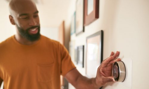 Man adjusts smart thermostat