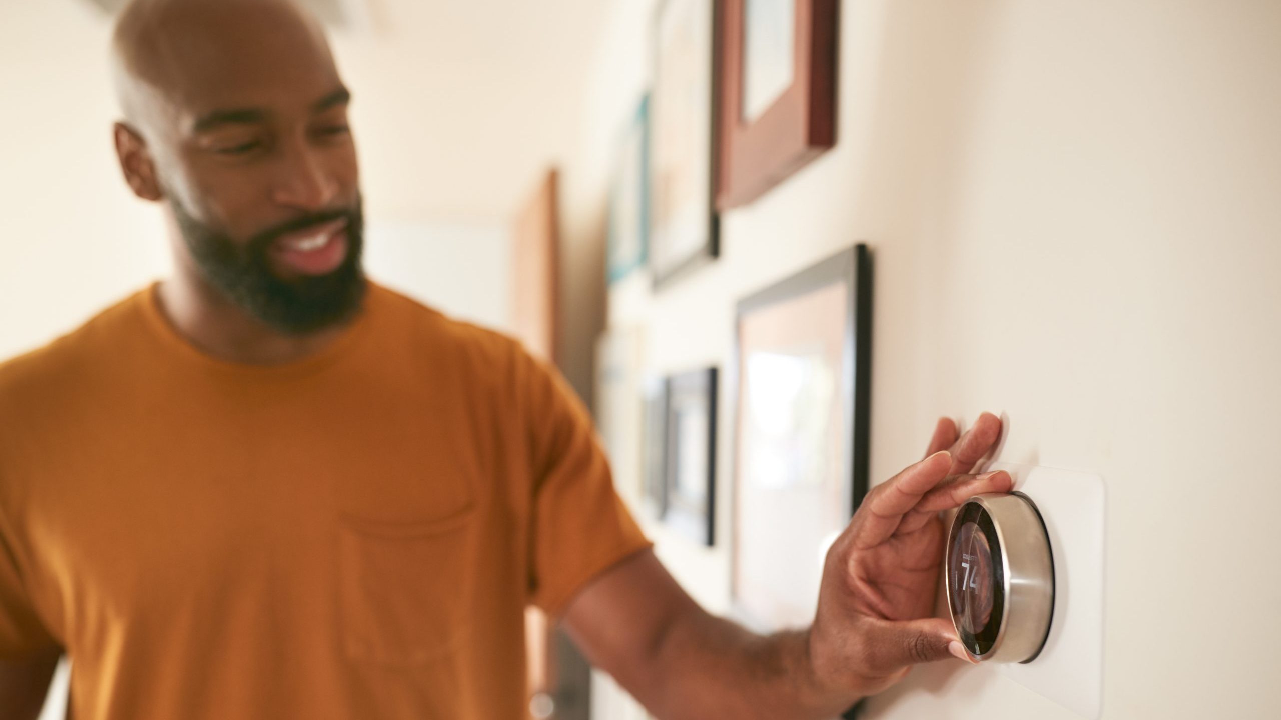 Man adjusts smart thermostat
