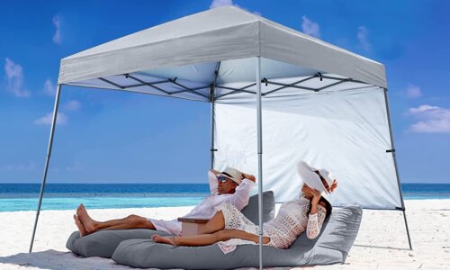 beach tent with couple underneath in lounge chairs