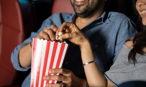 Couple eats popcorn at movie theater