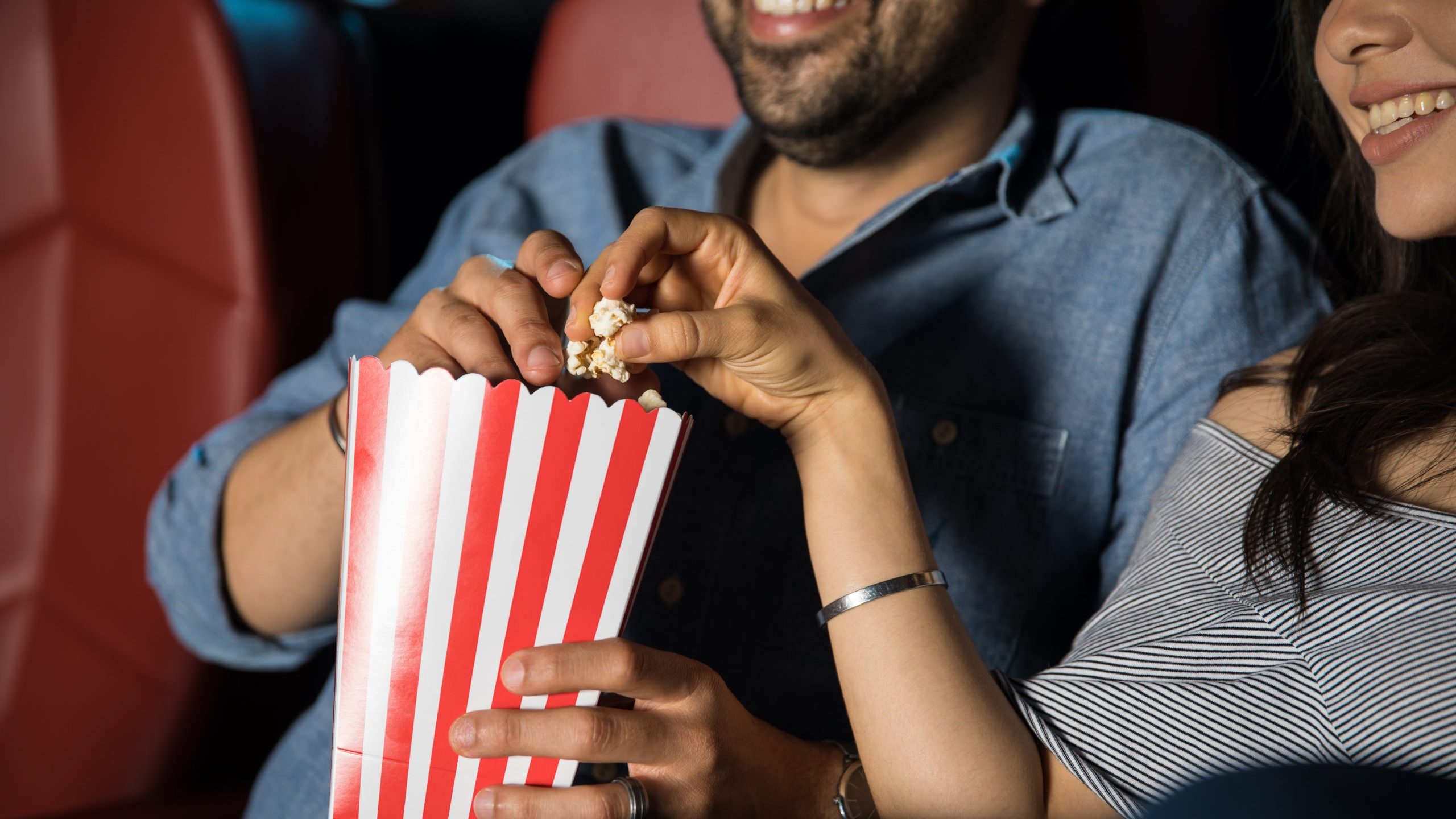 Couple eats popcorn at movie theater