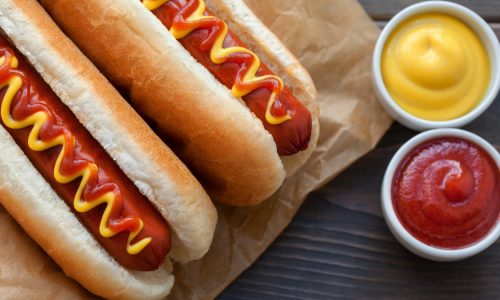 Two hot dogs with ketchup and mustard.