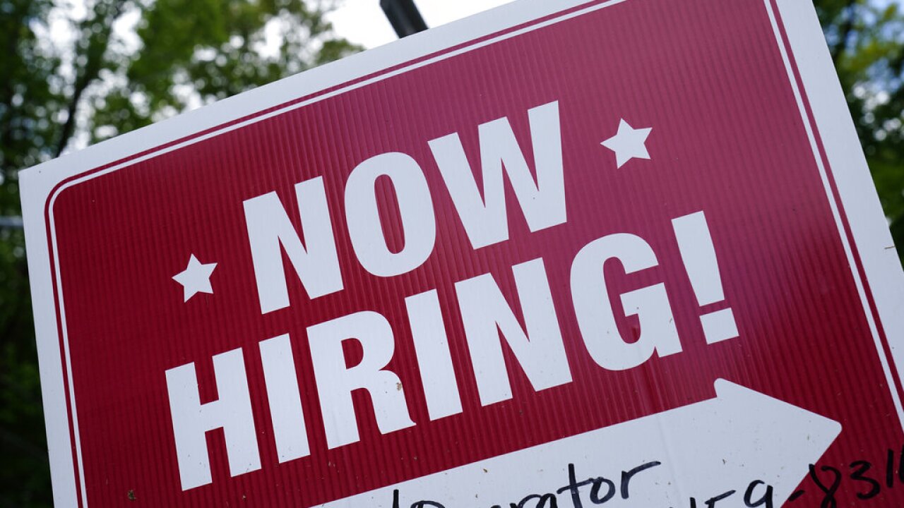 A "now hiring" sign is posted in Garnet Valley, Pa., Monday, May 10, 2021. Applications for unemployment benefits inched down last week, Thursday, April 21, 2022, as the total number of Americans collecting aid fell to its lowest level in more than 50 years. (AP Photo/Matt Rourke, File)