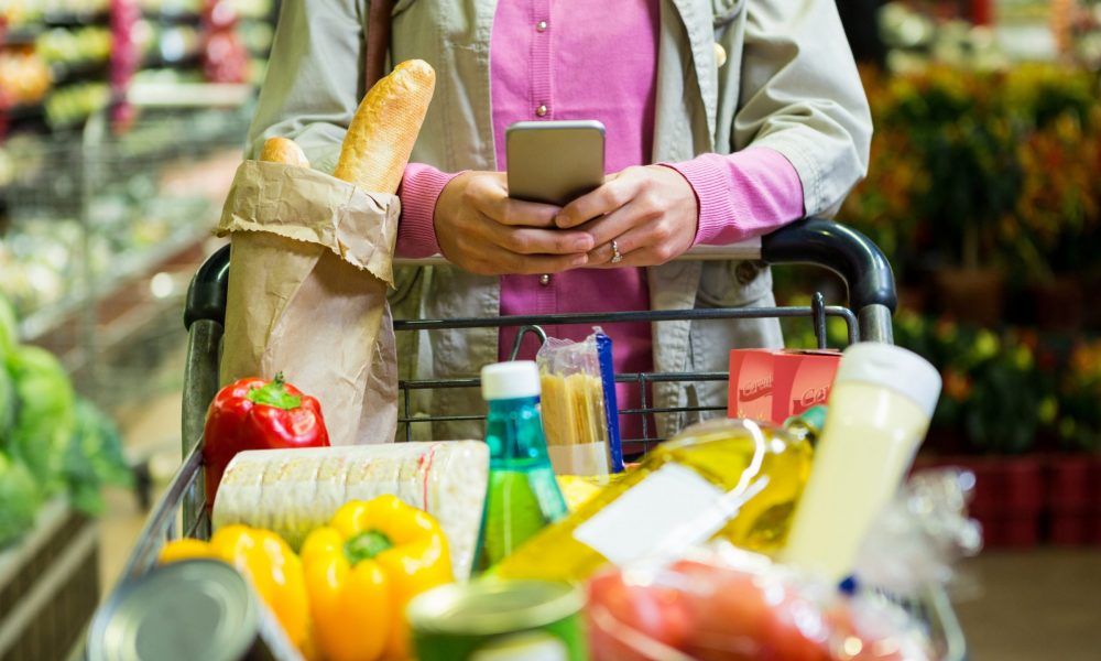 Shopper uses mobile phone at grocery store