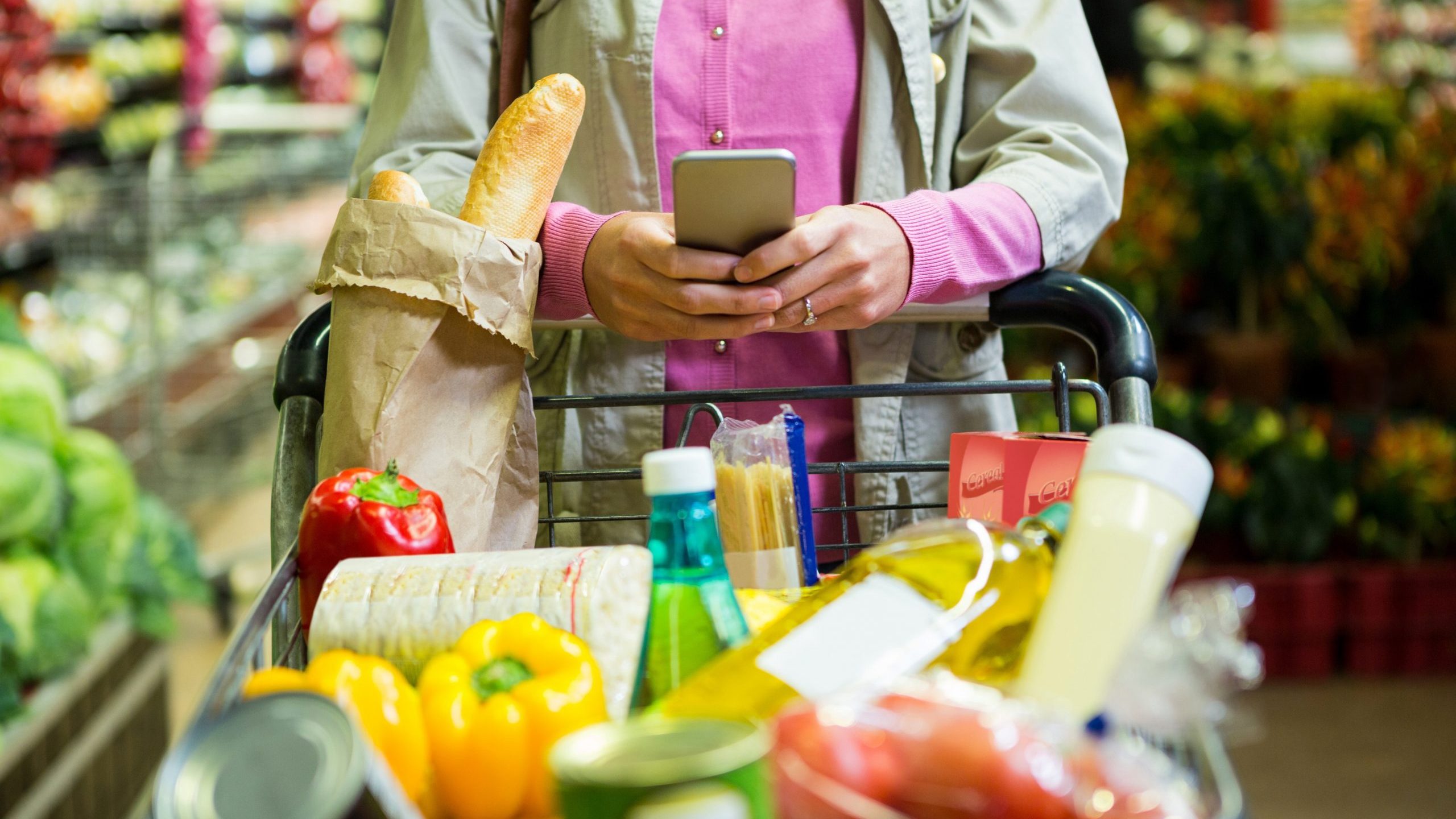 Shopper uses mobile phone at grocery store