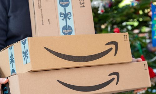 Amazon boxes with gifts, Christmas tree in background
