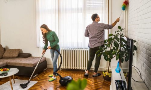 A young couple cleans their house together.