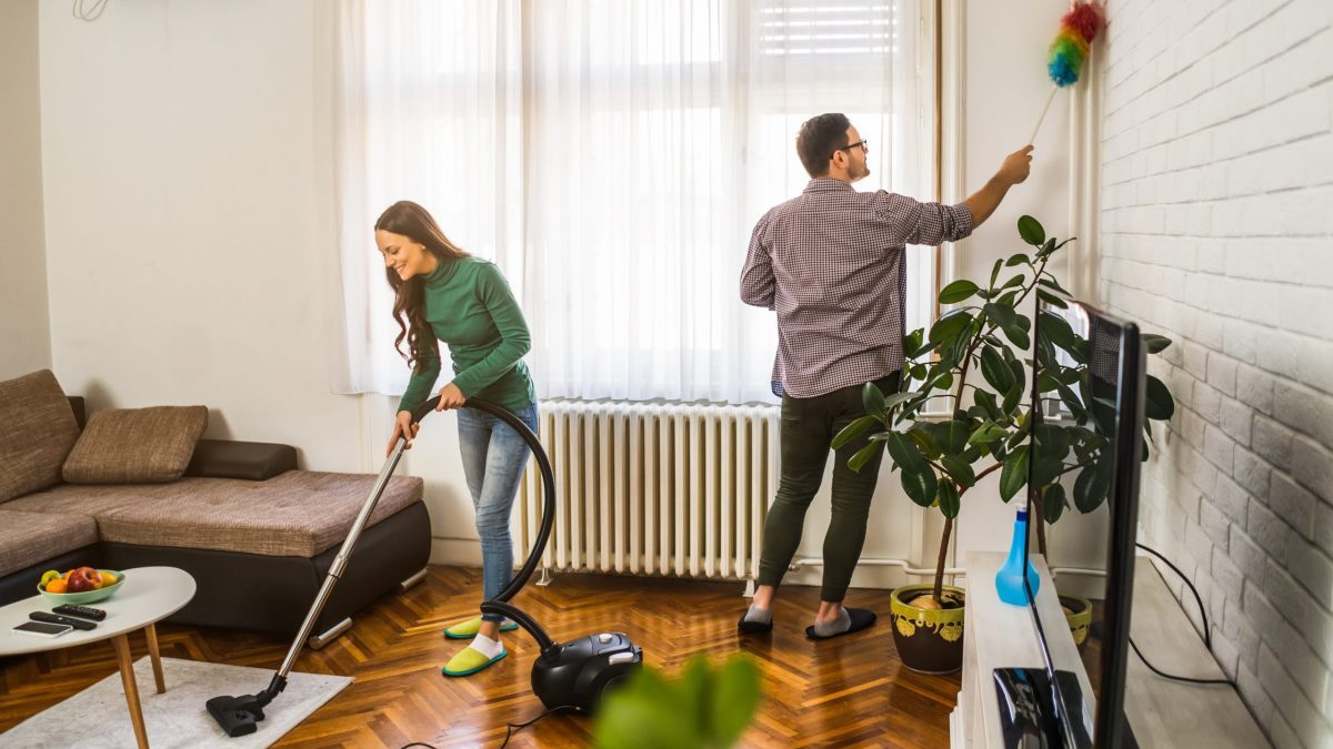 A young couple cleans their house together.