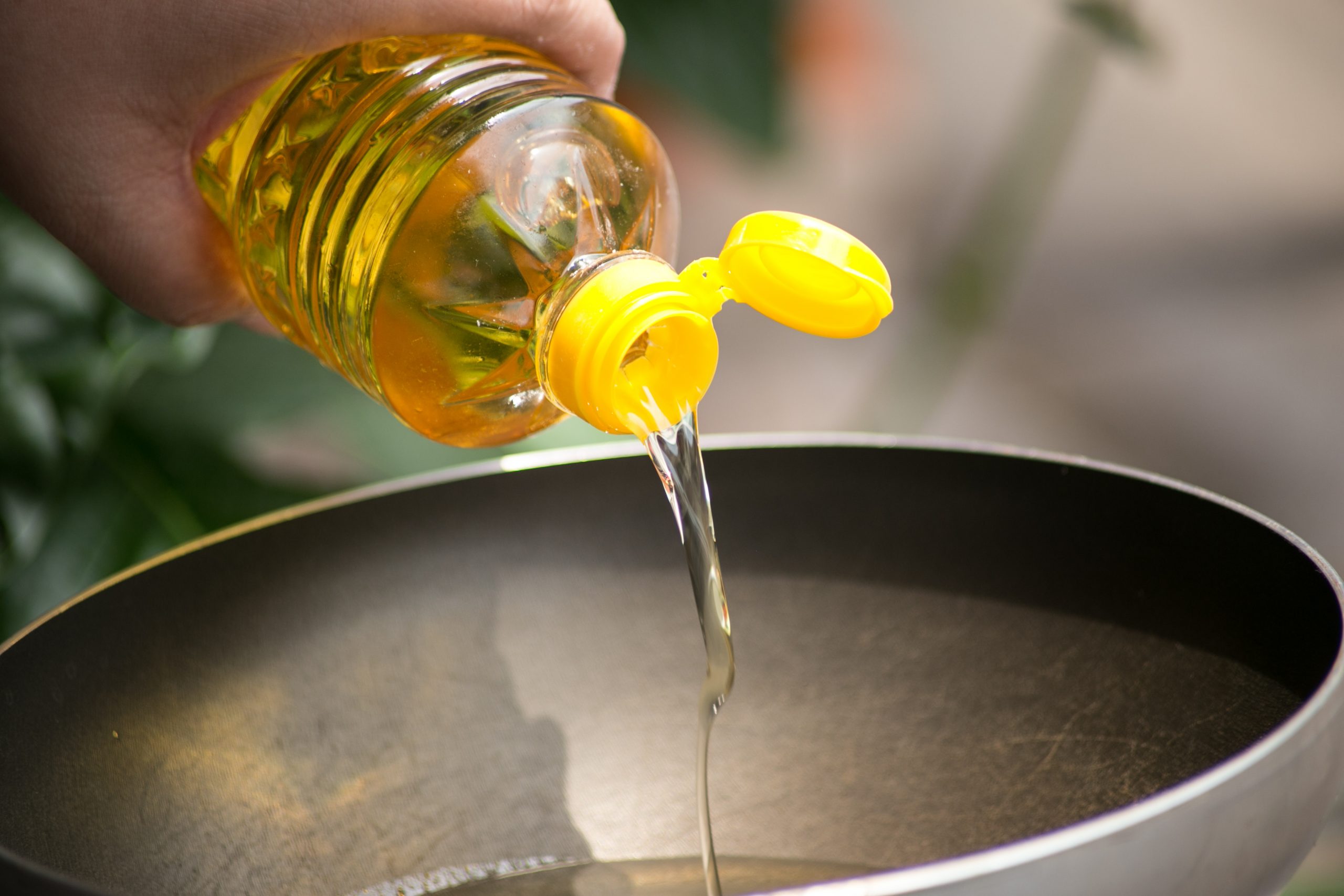 Pouring food oil in hot pan for deep frying