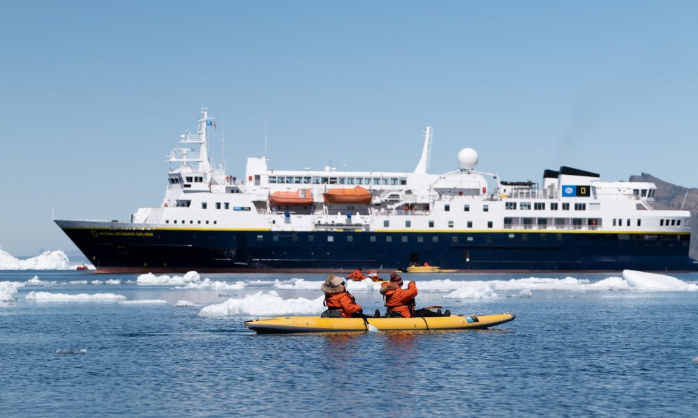 Nat Geo Explorer ship in icy sea with kayakers