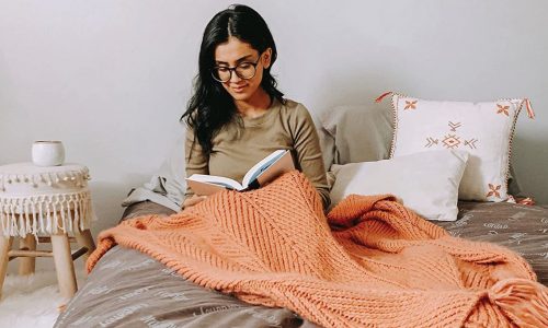Woman reads in beanbag chair bed