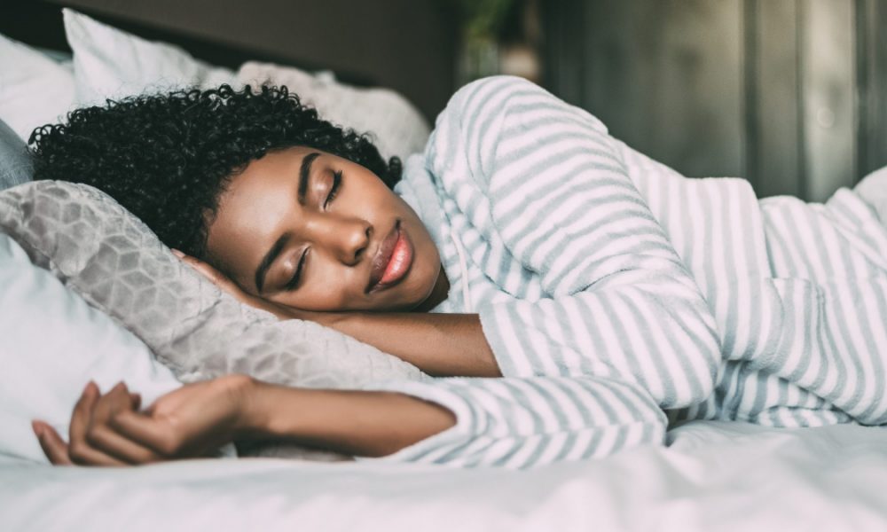 Woman sleeps comfortably in bed