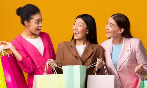 Happy women hold shopping bags