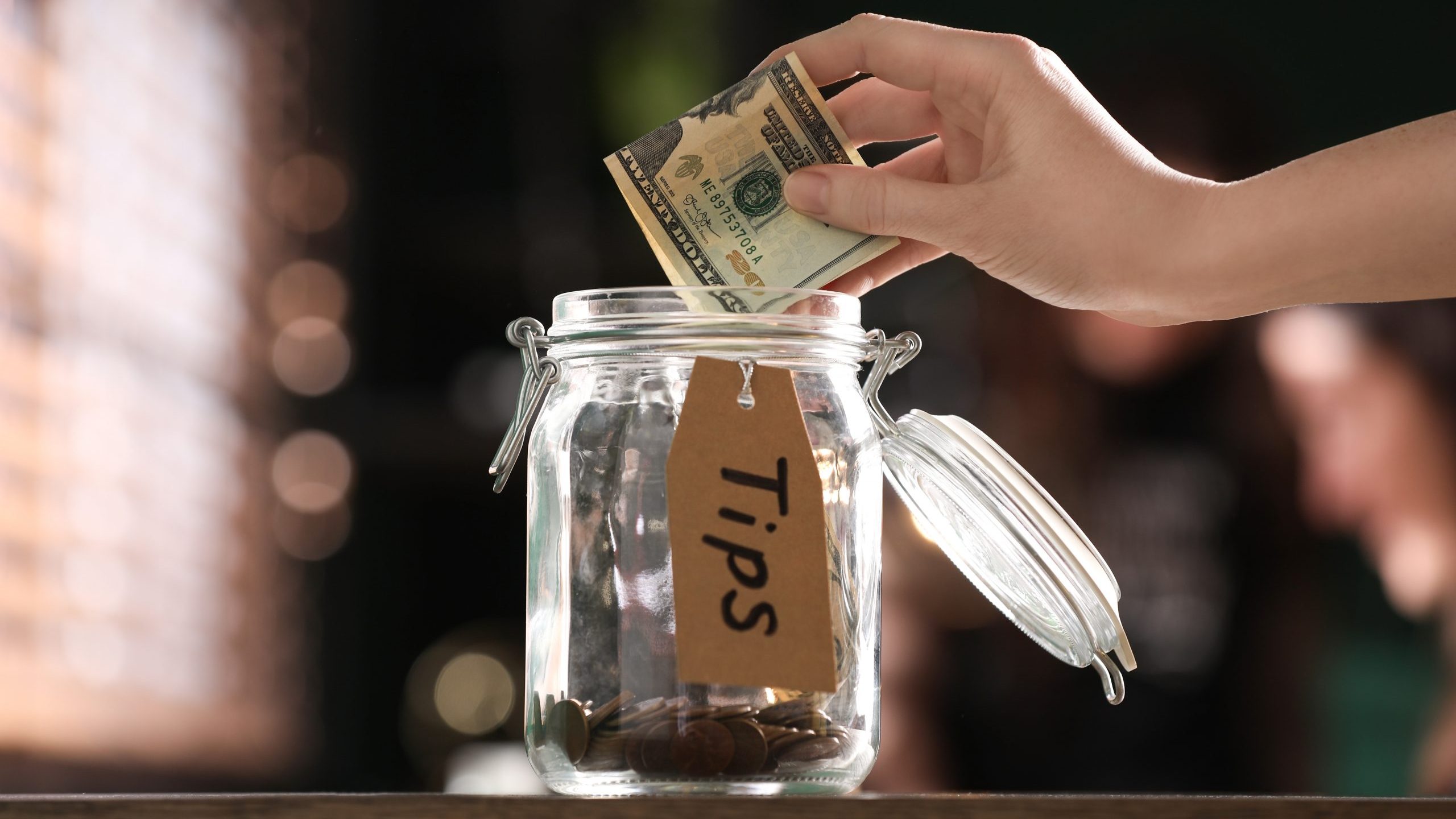 Woman puts tip in jar