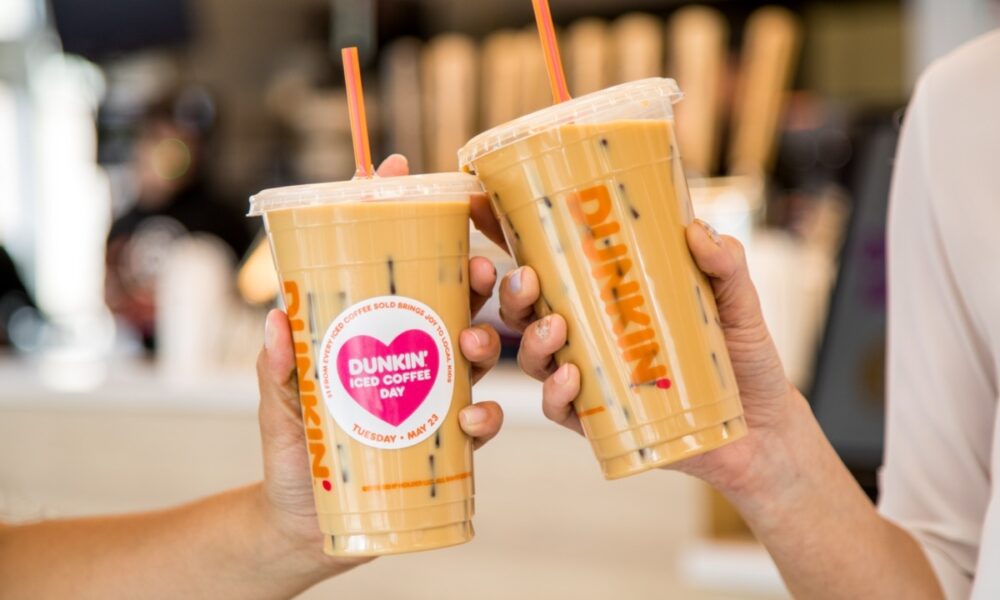 Hands hold Dunkin' cold brew coffees