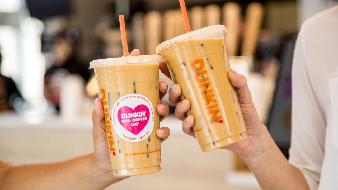 Hands hold Dunkin' cold brew coffees