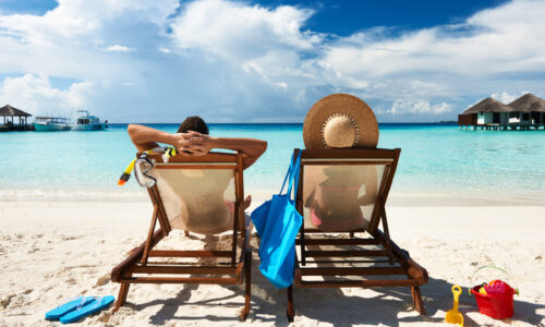 Couple in lounge chairs on beach vacation
