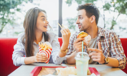 Friends eat fries, burger at fast food restaurant