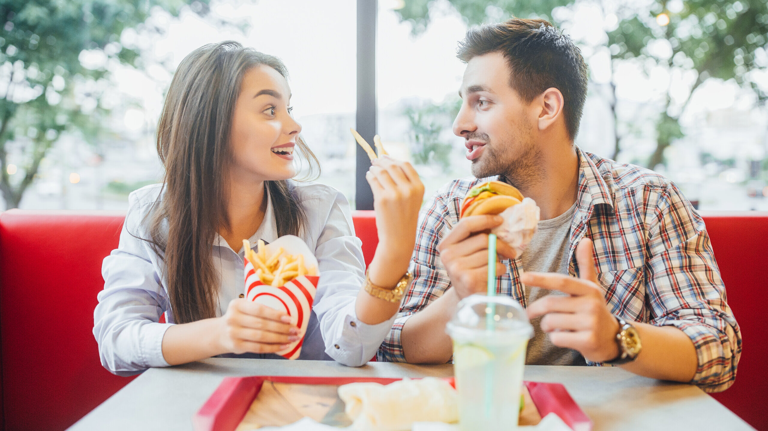 Friends eat fries, burger at fast food restaurant