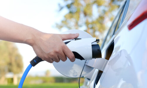 Hand attaches charger to electric car